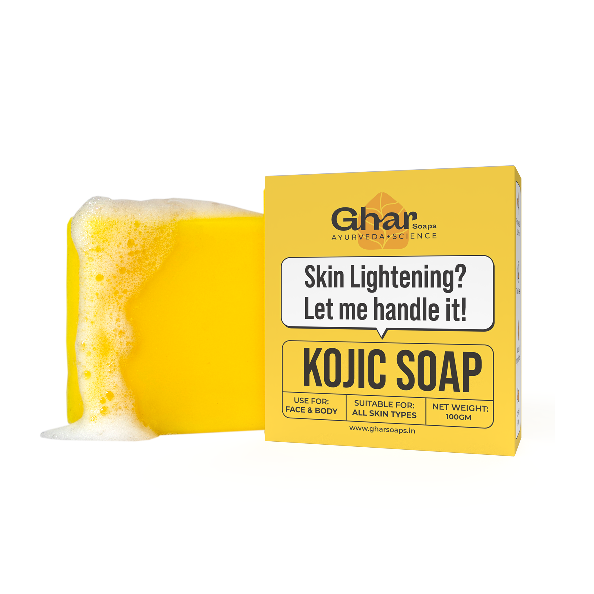 A yellow bar of soap with bubbles is placed next to a yellow box labeled “KOJIC SOAP” for skin lightening by Ghar, suitable for all skin types, 100g.